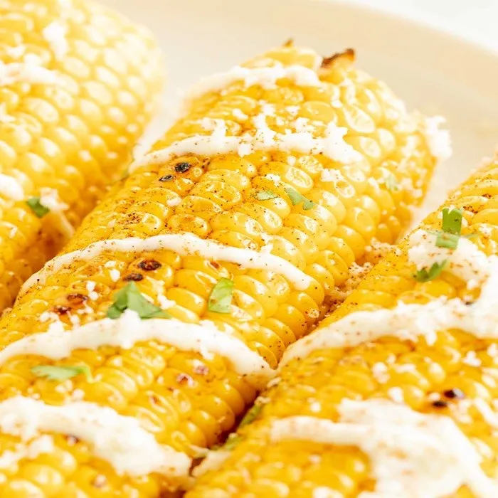 Maíz a la parrilla con mayonesa de ajo y queso rallado