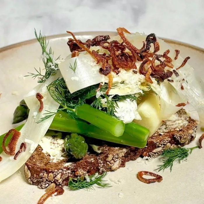 Smørrebrød nórdico con espárragos y crema de rábano picante