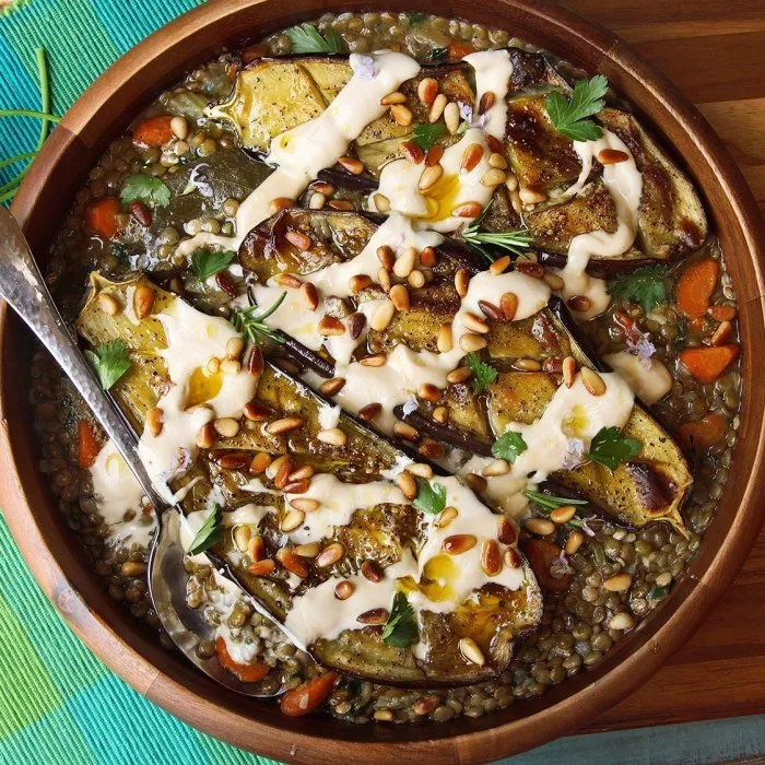 Berenjena asada con tahini, piñones y lentejas